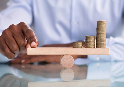 A man balancing coins on a scale